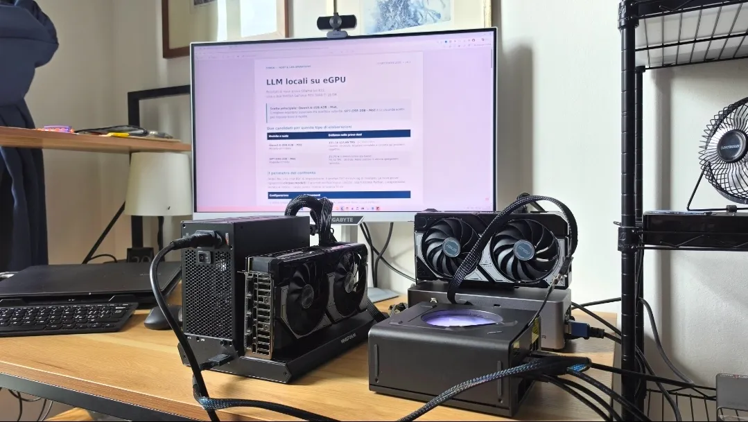 Il laboratorio: un mini PC con due schede video esterne collegate, davanti a un monitor con un report di misure.